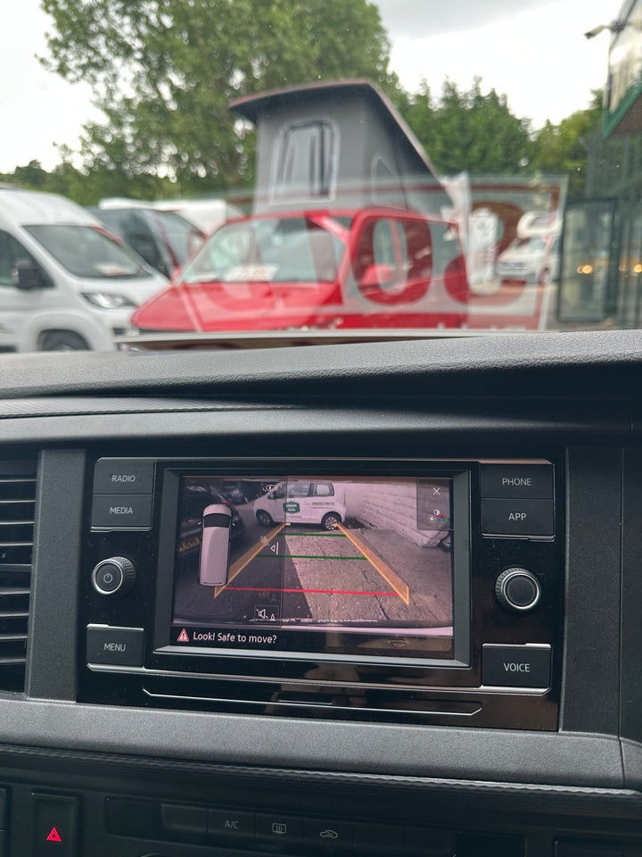 Radio screen showing a reversing camera view with guide lines and the message Look! Safe to move?