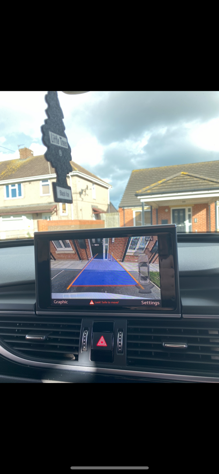 Dashboard screen showing a rear camera view with guide lines, labelled ‘Graphic’ and ‘Settings’, and ‘Look! Safe to move?’